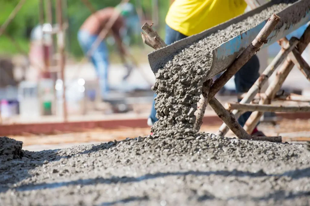 Close-up of fresh concrete being poured by Southlake TX concrete contractors, showing the detailed process of concrete mixture consistency and proper placement techniques.